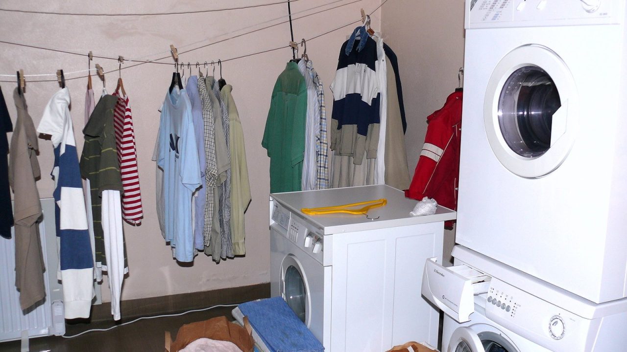 Buanderie avec sécheuse superposée sur une laveuse à chargement frontal et linge suspendu